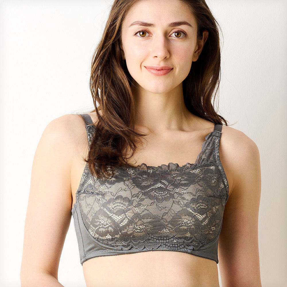 チャコールの胸を小さく見せるブラ、メイン商品画像。レース素材のブラを着用した女性モデルが微笑む正面写真。快適な着心地とエレガントなデザインを強調