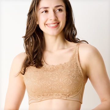 ベージュの胸を小さく見せるブラ、メイン商品画像。黒いレース素材のブラを着用した女性モデルが微笑む正面写真。快適な着心地とエレガントなデザインを強調