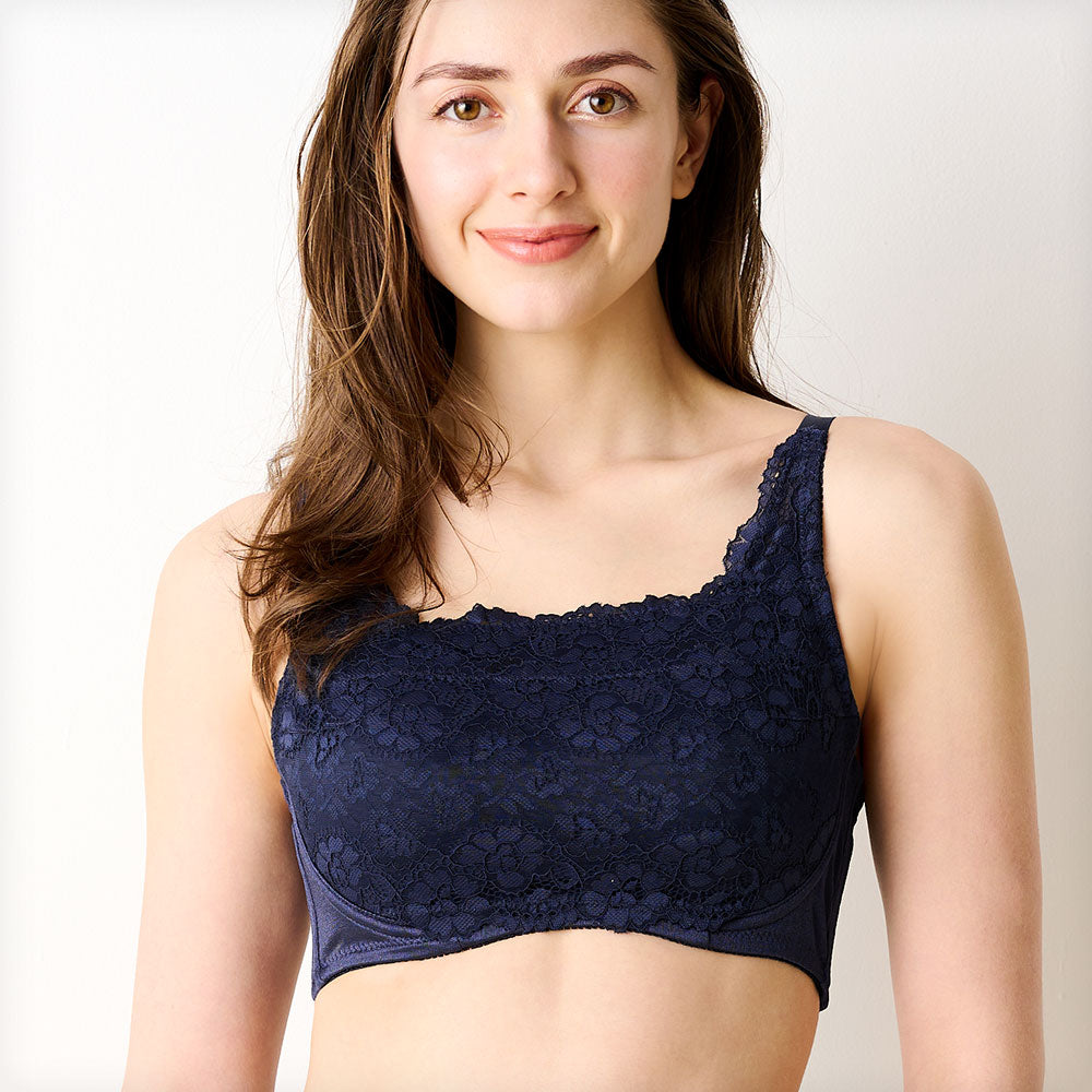 ネイビーの胸を小さく見せるブラ、メイン商品画像。黒いレース素材のブラを着用した女性モデルが微笑む正面写真。快適な着心地とエレガントなデザインを強調
