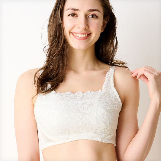 オフホワイトの胸を小さく見せるブラ、メイン商品画像。黒いレース素材のブラを着用した女性モデルが微笑む正面写真。快適な着心地とエレガントなデザインを強調